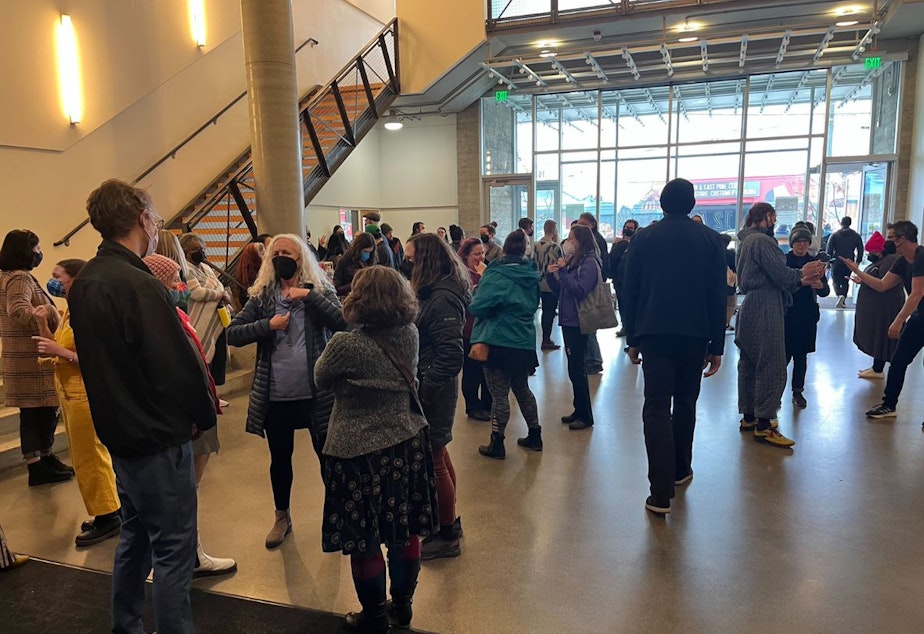 caption: Audience members and actors gather in the lobby of 12th Avenue Arts after the final performance of Deaf Spotlight’s Short Play Festival on March 5, 2023.