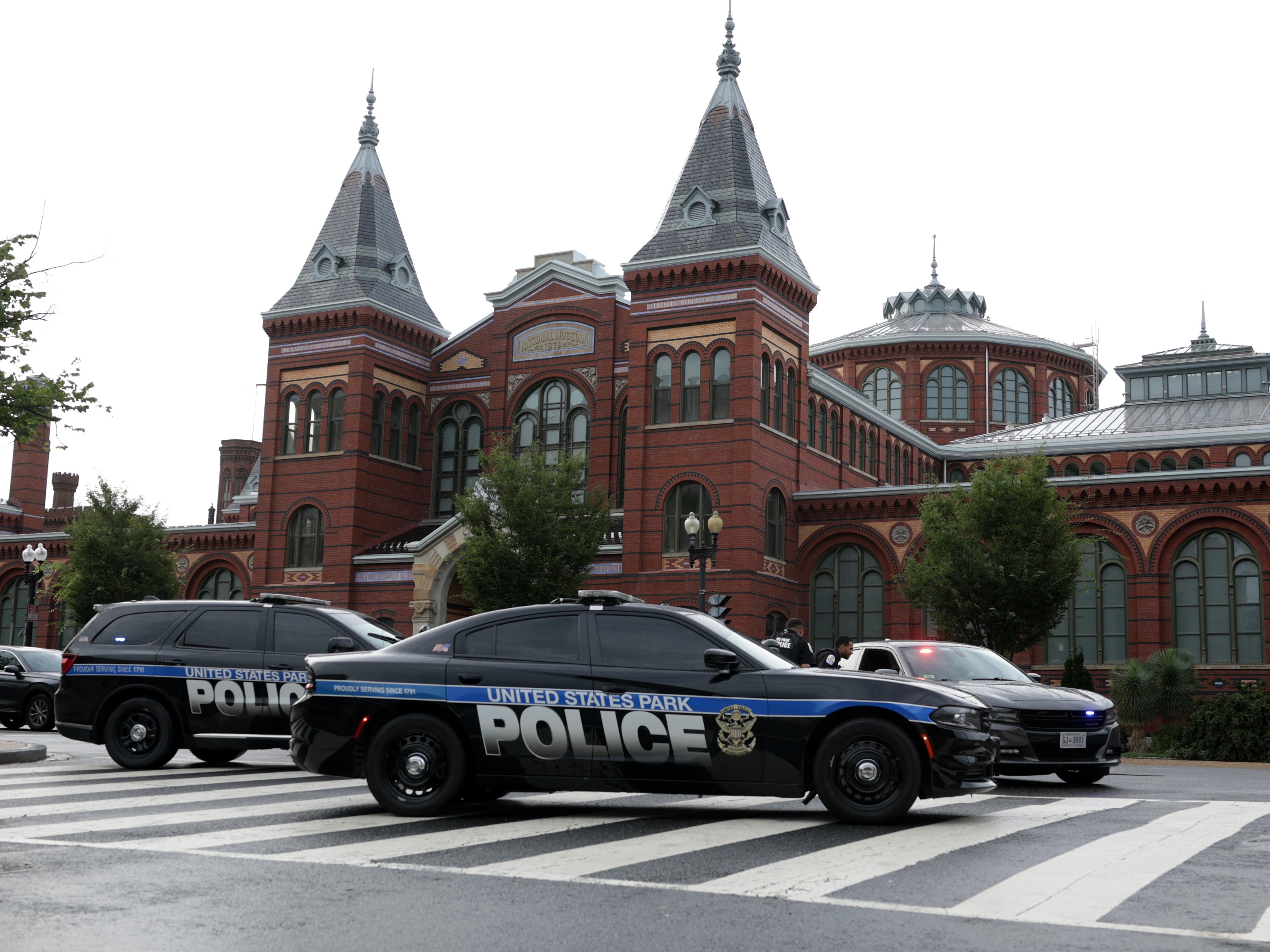 caption: Members of the U.S. Park Police guard an entrance to the 9th Street tunnel in front of the Smithsonian Castle on Aug. 13, 2025, in Washington, D.C., after the Trump administration initiated a federal takeover of D.C. police and deployed the National Guard in the city.