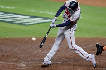 caption: Freddie Freeman of the Atlanta Braves hits a solo home run against the Houston Astros in Game Six of the World Series in November.