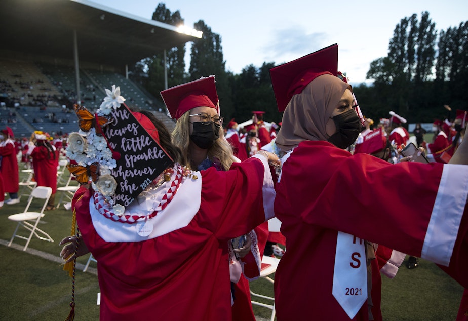 caption: Cleveland Stem High School seniors celebrate after graduating in-person on Tuesday, June 15, 2021, at Memorial Stadium in Seattle. 