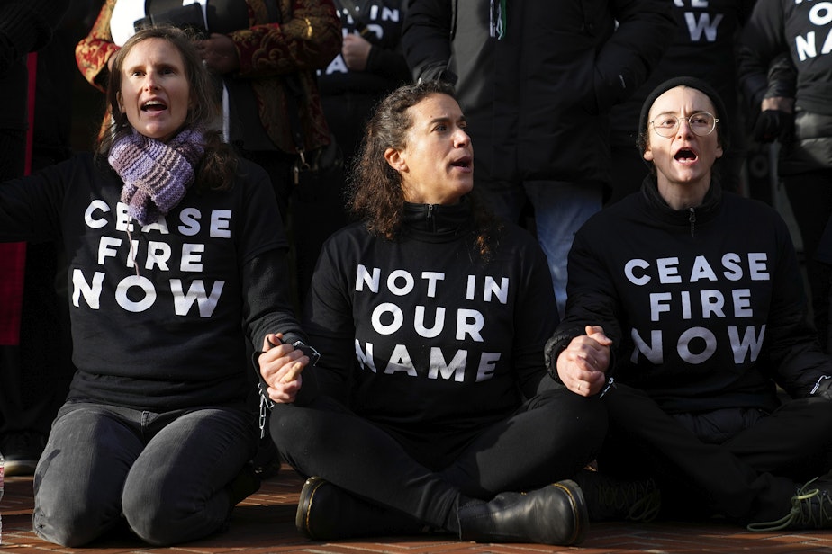 caption: Protesters lock hands during a Jewish Voice for Peace rally outside the Henry M. Jackson Federal Building while demanding that Sen. Patty Murray, D-Wash., call for a ceasefire in the Israel-Hamas war Friday, Nov. 3, 2023, in Seattle.