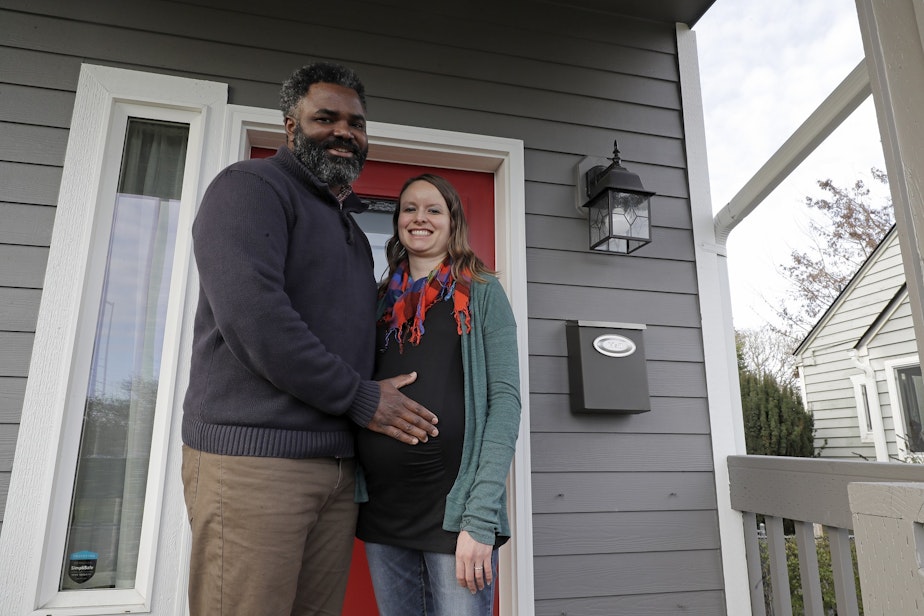 caption: Kate and Quantas Ginn pose for a photo Sunday, Dec. 29, 2019 at their home in Tacoma, Wash. Kate Ginn, who was expecting a baby in late January, was planning to submit paperwork on Thursday, Jan. 2, 2020 to apply for paid time off from her job as a project manager for a non-profit organization under Washington state's new paid family leave law. 