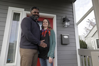 caption: Kate and Quantas Ginn pose for a photo Sunday, Dec. 29, 2019 at their home in Tacoma, Wash. Kate Ginn, who was expecting a baby in late January, was planning to submit paperwork on Thursday, Jan. 2, 2020 to apply for paid time off from her job as a project manager for a non-profit organization under Washington state's new paid family leave law. 