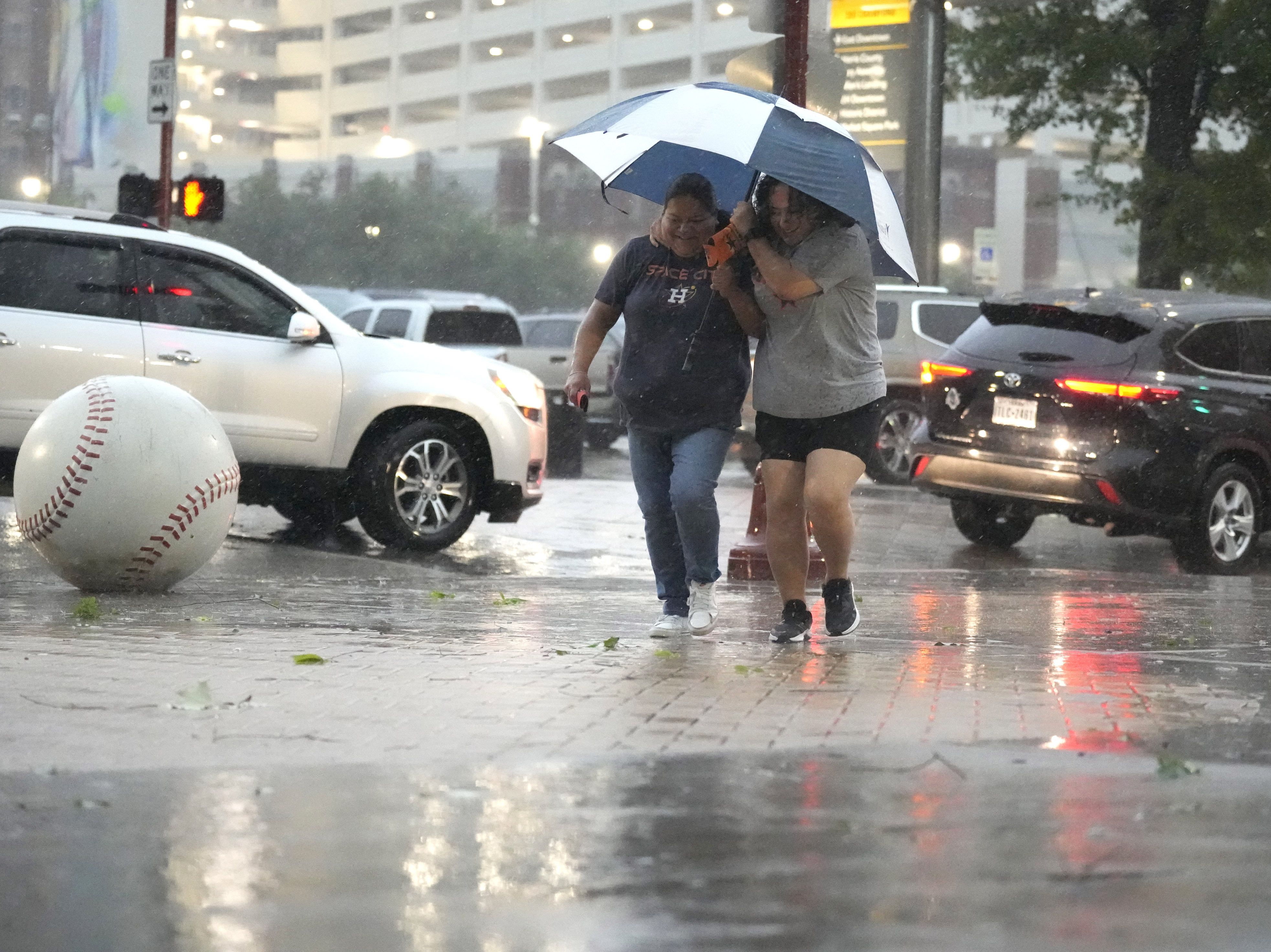 caption: Fans make their way into Minute Maid Park as a severe thunderstorm hit before a baseball game between the Oakland Athletics and the Houston Astros, Thursday, May 16, 2024, in Houston.