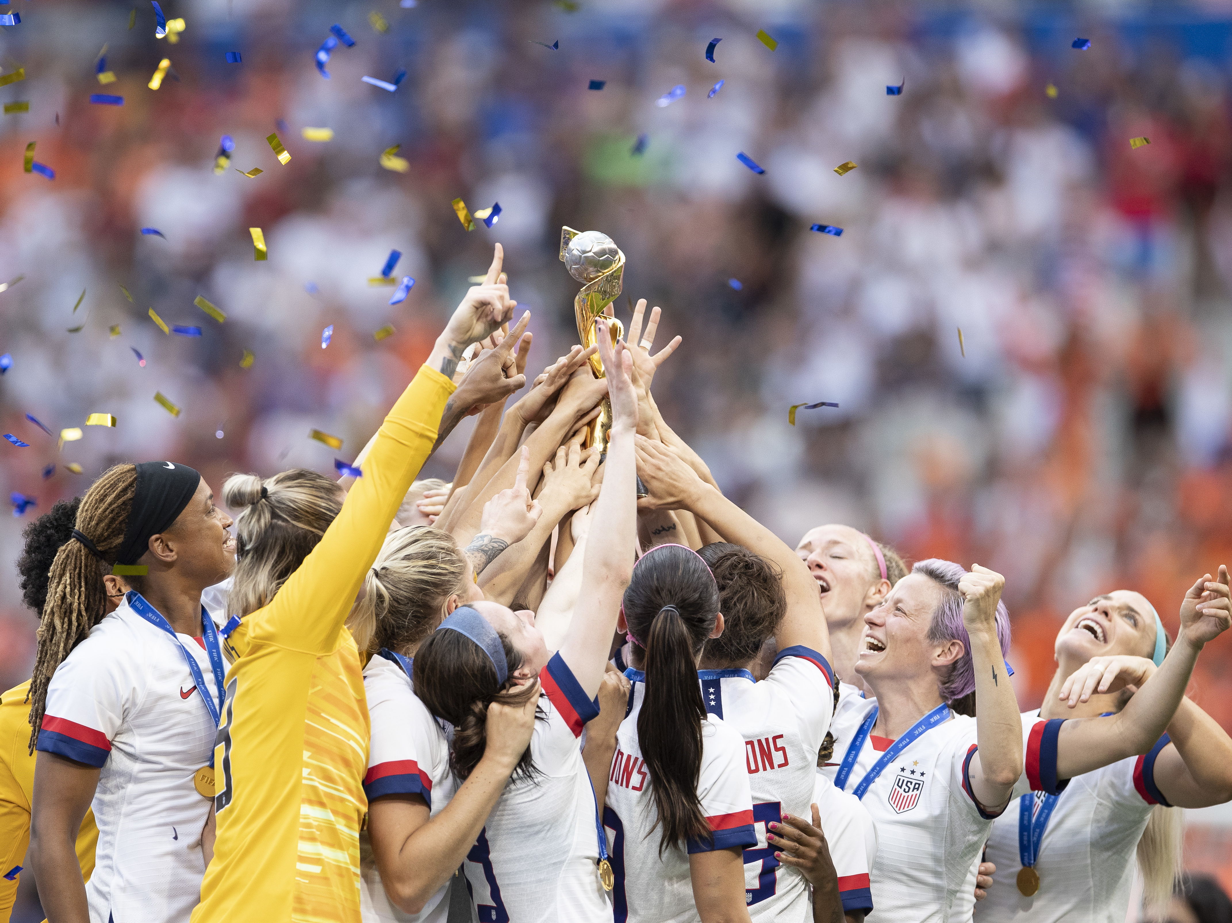 caption: U.S. Women's National Team players celebrate with the FIFA Women's World Cup Trophy following team's victory Sunday.