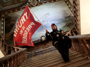 caption: A protester holds a Trump flag inside the U.S. Capitol near the Senate Chamber.
