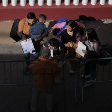 caption: A migrant family shows their paperwork to Mexican immigration officials to proceed with their CBP One asylum appointments at the Chaparral pedestrian border in Tijuana, Mexico to cross to the U.S. on Thursday.