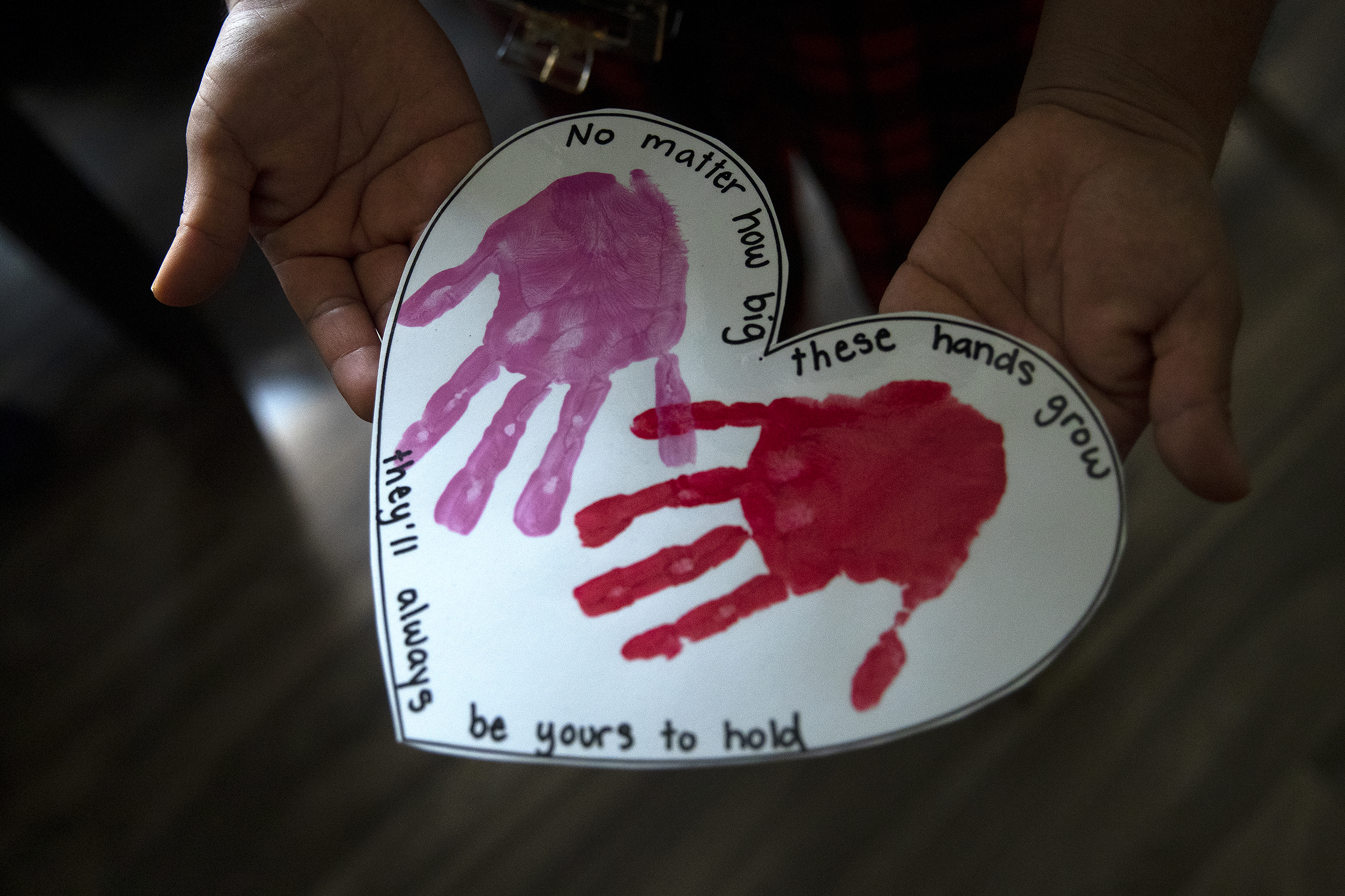 caption: A Oaxacan woman holds artwork created by her UW-born daughter, at her Mount Vernon apartment on Thursday, March 5, 2026. 