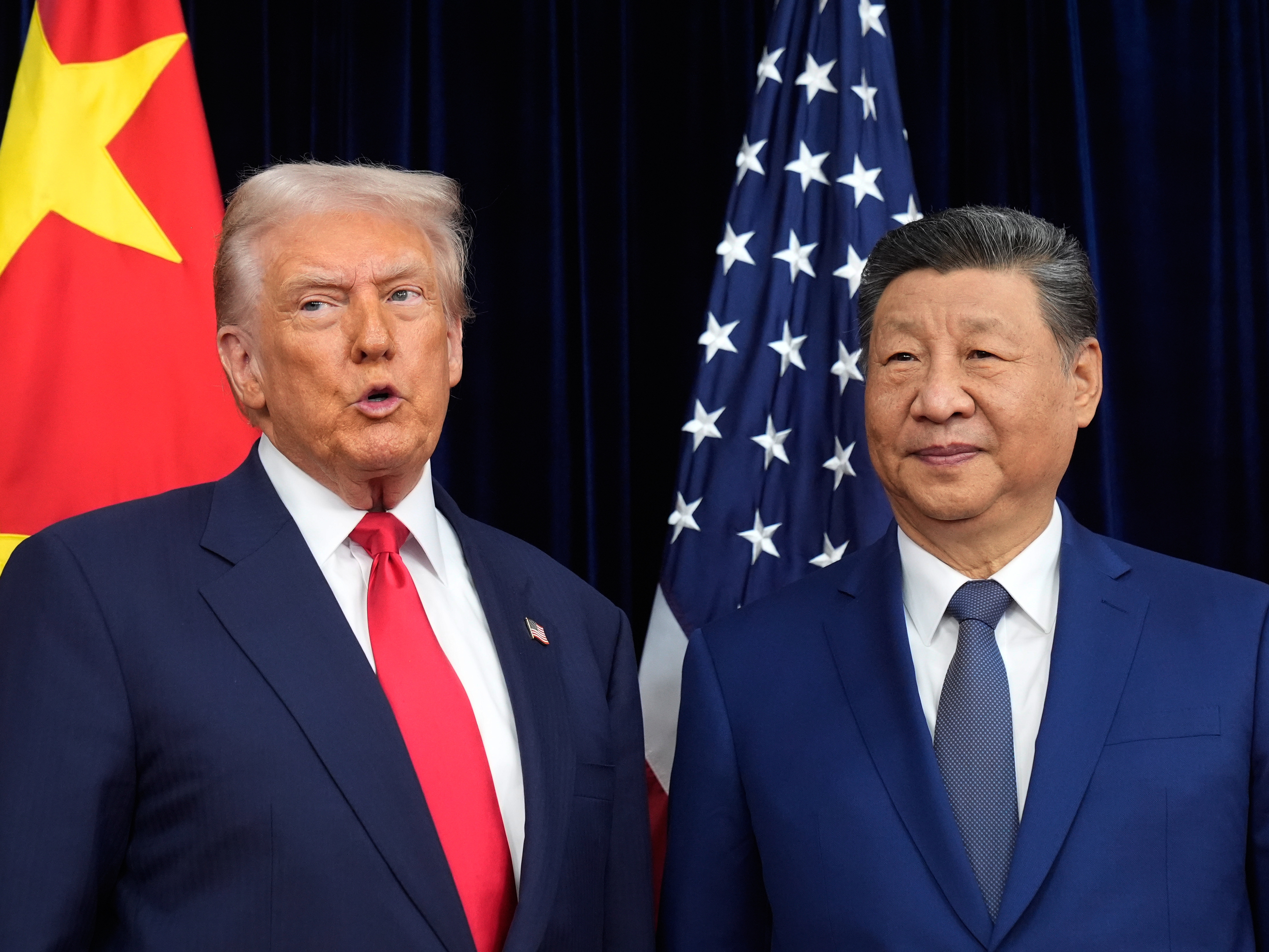 caption: President Donald Trump, left, and Chinese President Xi Jinping pose together ahead of their summit talk at Gimhae International Airport in Busan, South Korea, on Thursday.