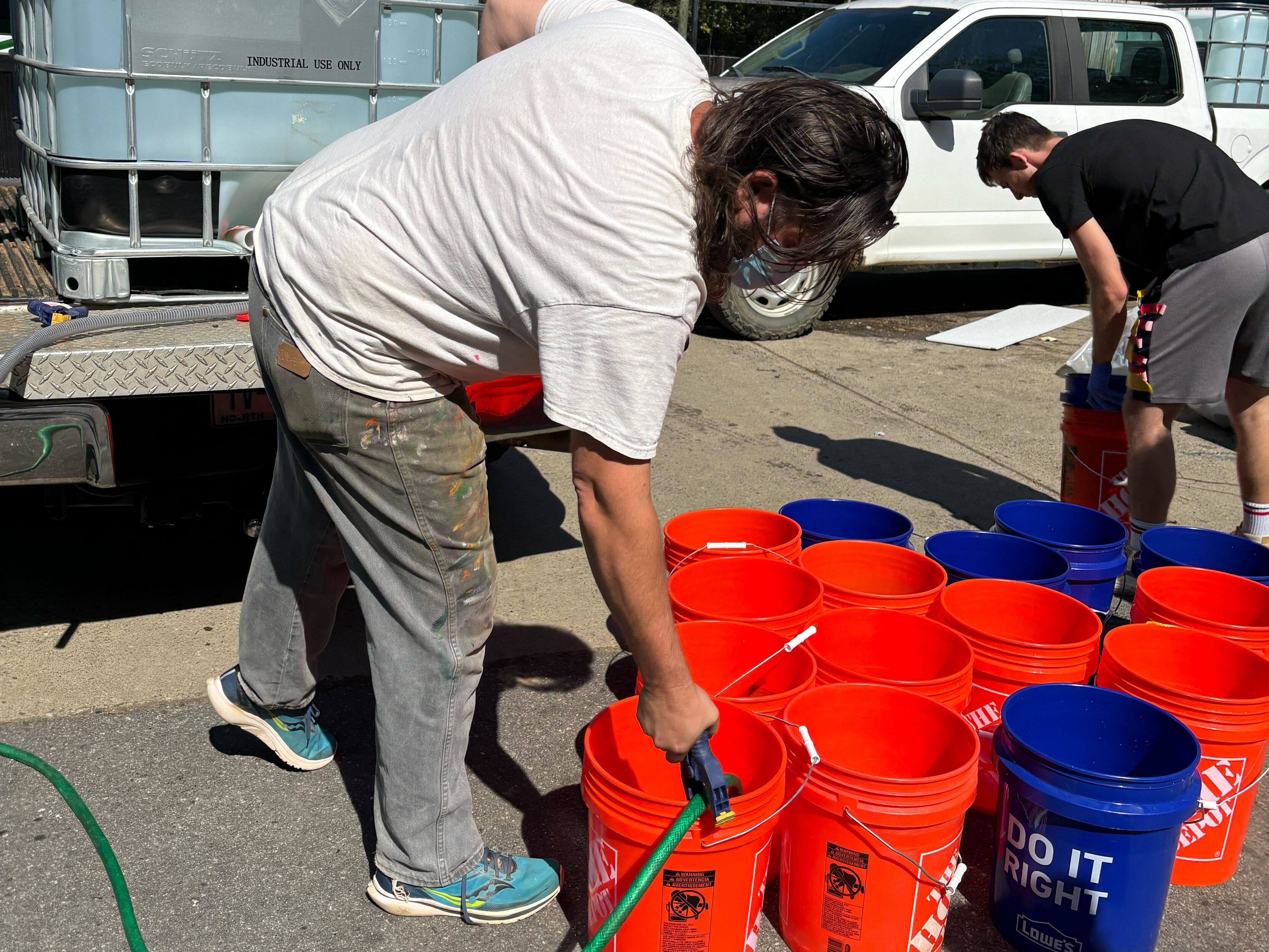 caption: Jerry Cahill has been flushing toilets as a volunteer since his studio in Asheville's River Arts District was destroyed by flooding from the remnants of Helene.