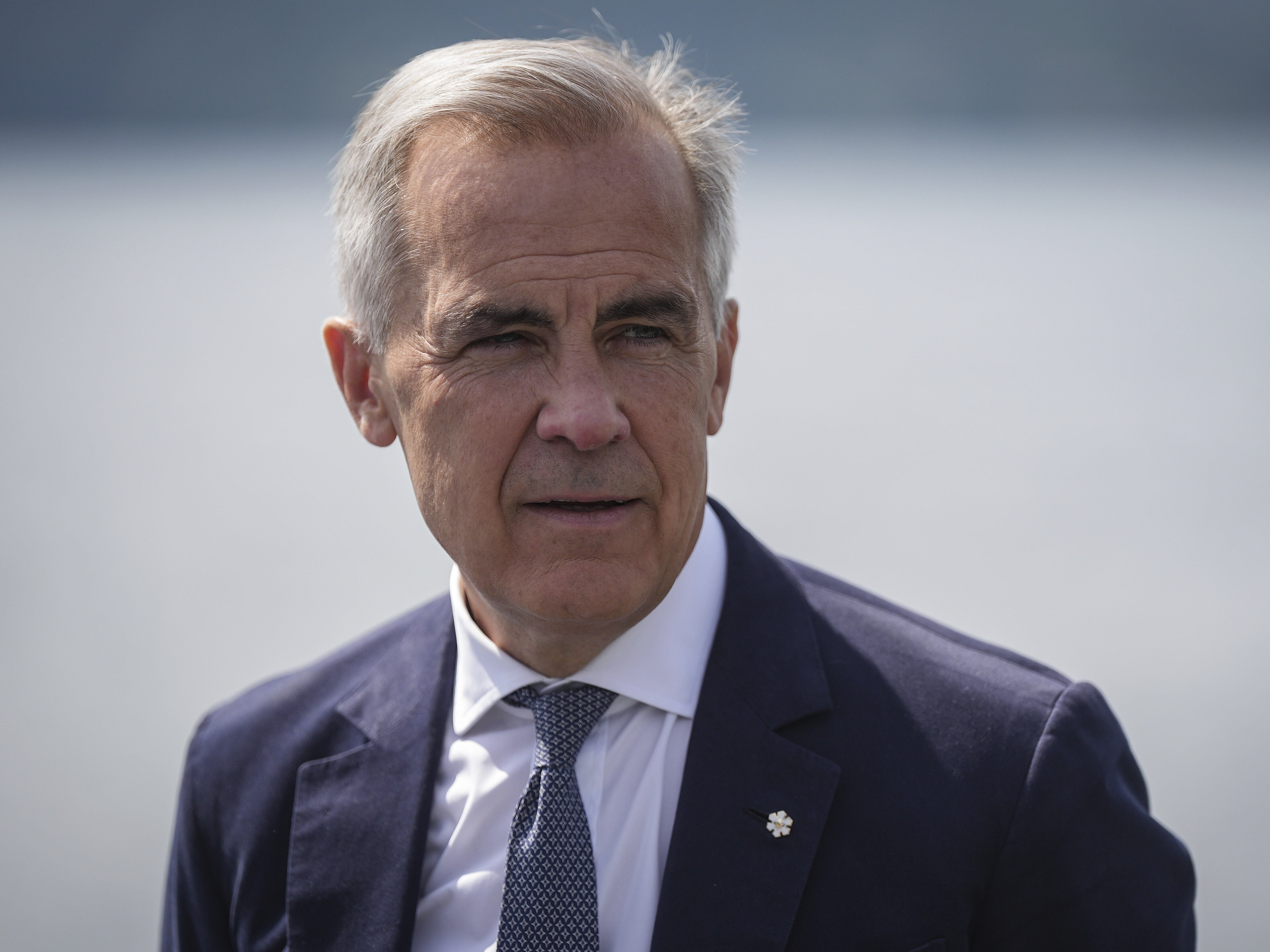 caption: Canada's Prime Minister Mark Carney listens while touring the Royal Canadian Navy torpedo recovery vessel Sikanni at the Canadian Forces Maritime Experimental and Test Ranges, in Nanoose Bay, British Columbia, Aug. 4.