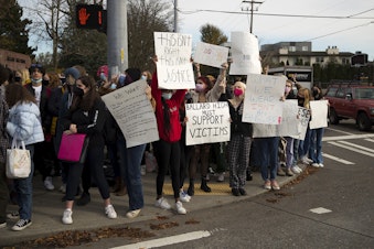 caption: Ballard High School students protest during lunch period at the intersection of Northwest 65th Street and 15th Avenue Northwest, while standing in solidarity with victims of sexual assault and presenting a list of demands for the school, on Monday, November 8, 2021, in Seattle.