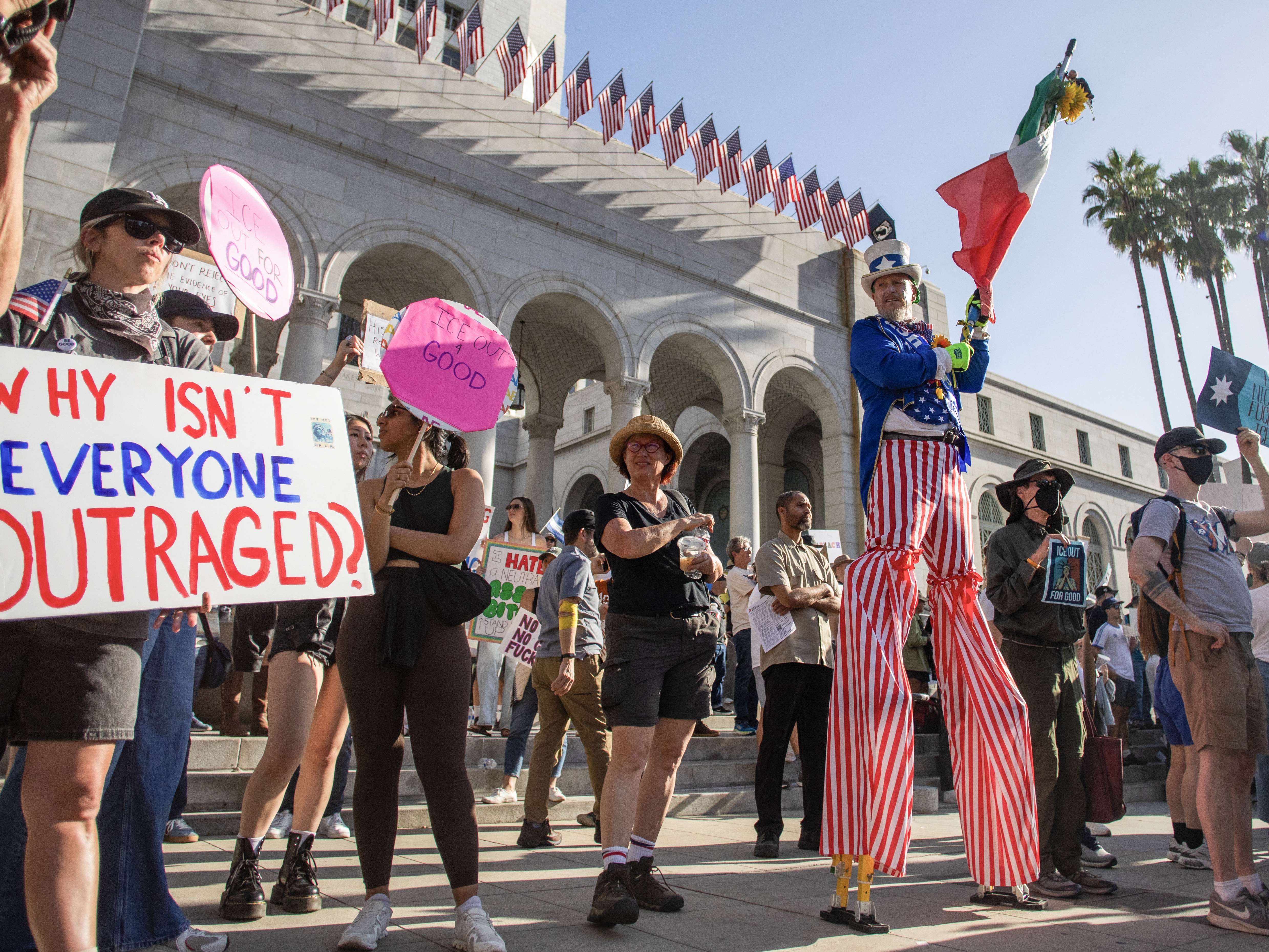 caption: Protesters demonstrate against federal immigration actions at an "ICE Out of Everywhere" rally in front of City Hall in downtown Los Angeles on Jan. 31.