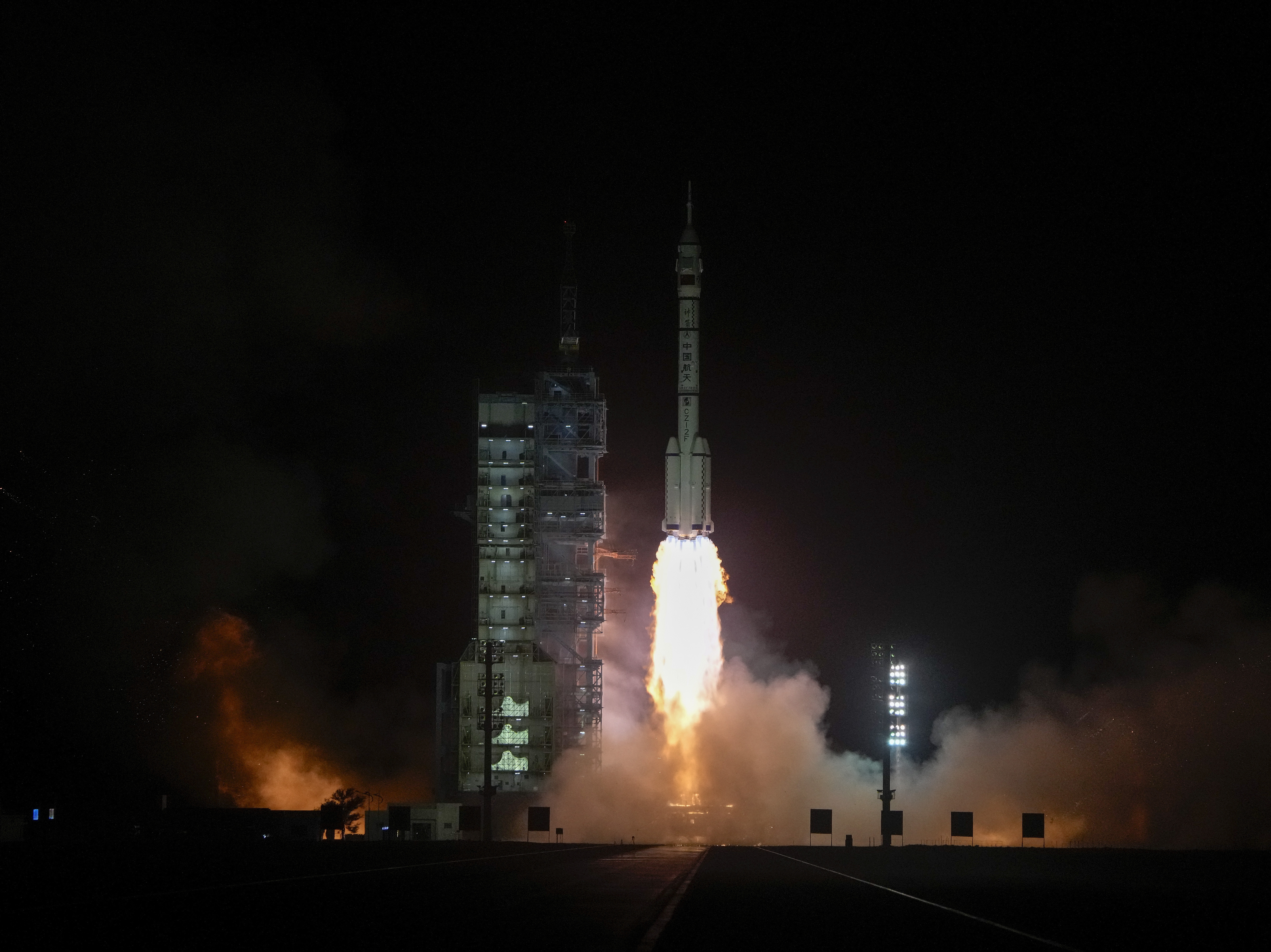 caption: A Long March rocket carrying a crew of Chinese astronauts in a Shenzhou-18 spaceship lifts off at the Jiuquan Satellite Launch Center in northwestern China on Thursday.