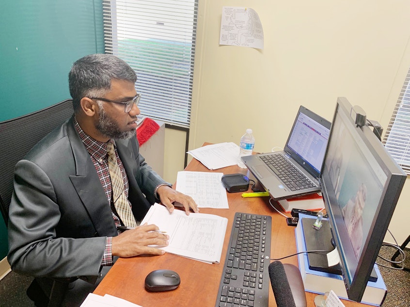 caption: Dr. Sarfraz Khan, chief medical officer at Meridian Health Services in Indiana, connects with patients over the internet.
