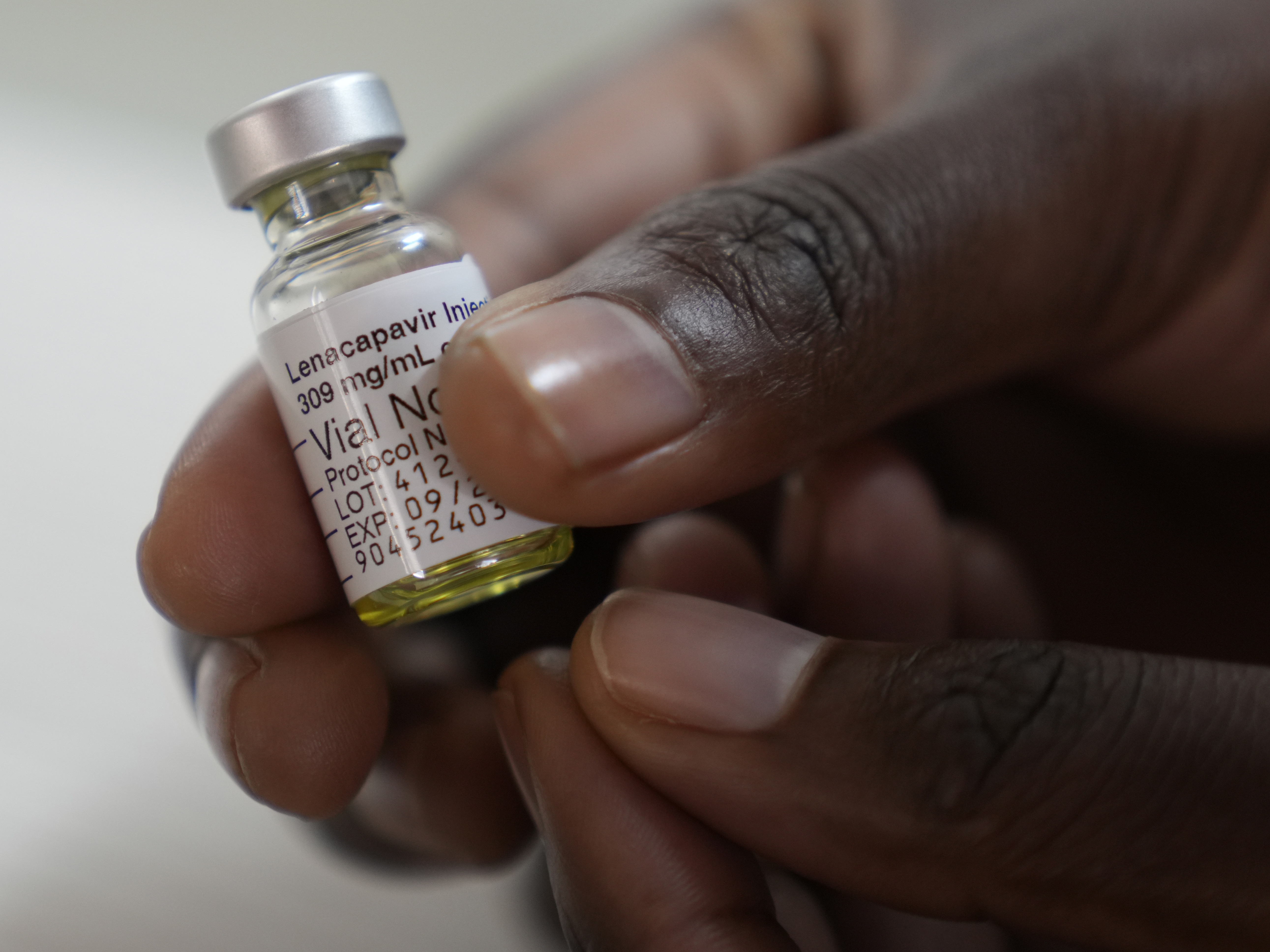 caption: A pharmacist holds a vial of lenacapavir, at the Desmond Tutu Health Foundation's Masiphumelele Research Site, in Cape Town, South Africa. The drug's development has been heralded as the 2024 Breakthrough of the Year by the journal <em>Science,</em> which described it as representing "a pivotal step toward diminishing HIV/AIDS as a global health crisis."