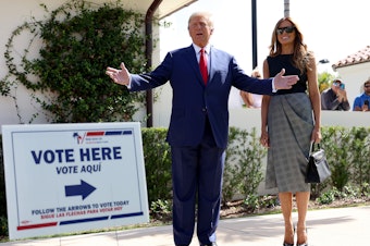 caption: Former President Donald Trump stands with former first lady Melania Trump after voting in 2022.