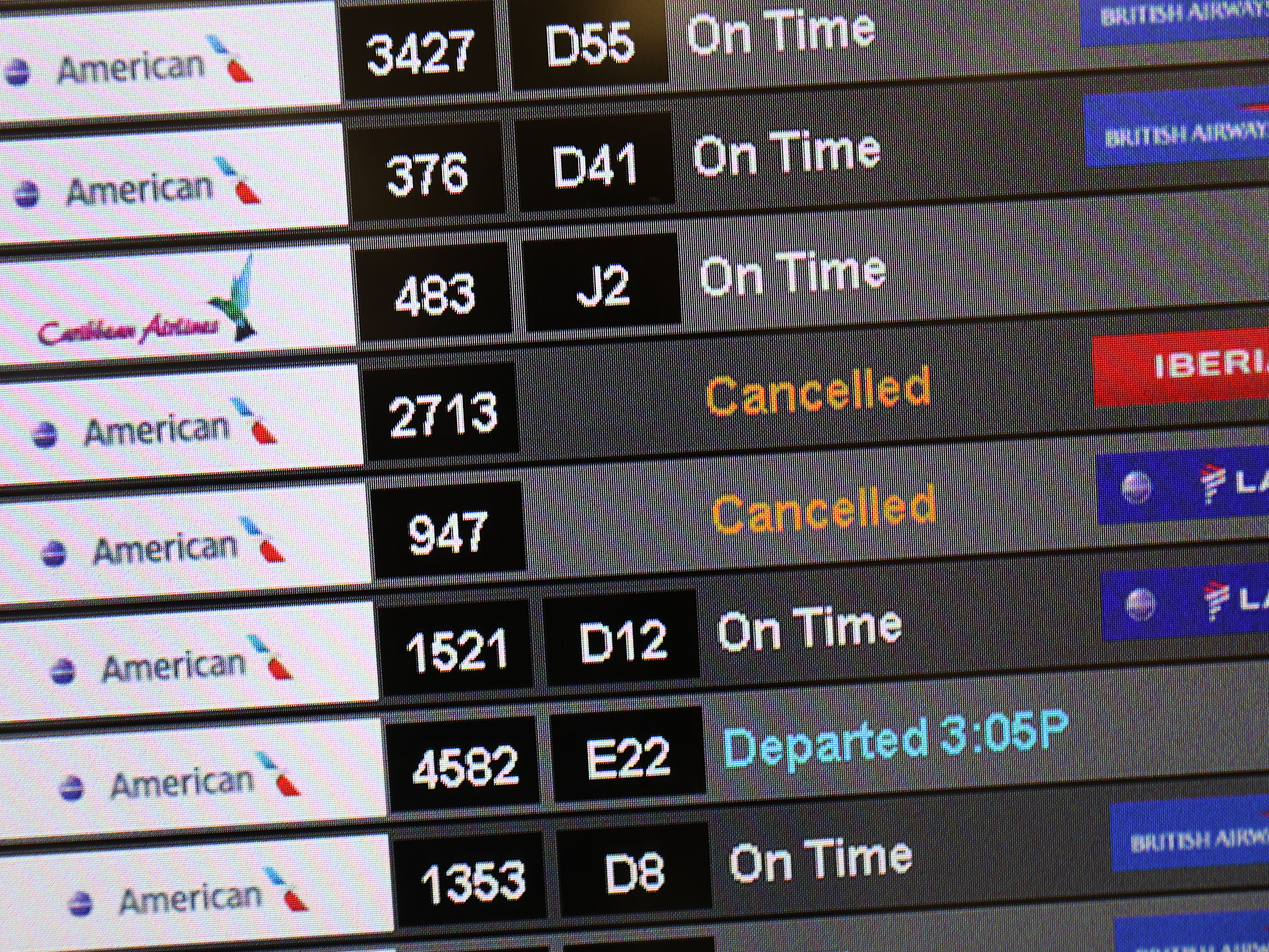 caption: A sign at the Miami International Airport shows cancelled flights after American Airlines initially grounded its Boeing 737 Max  planes in March.