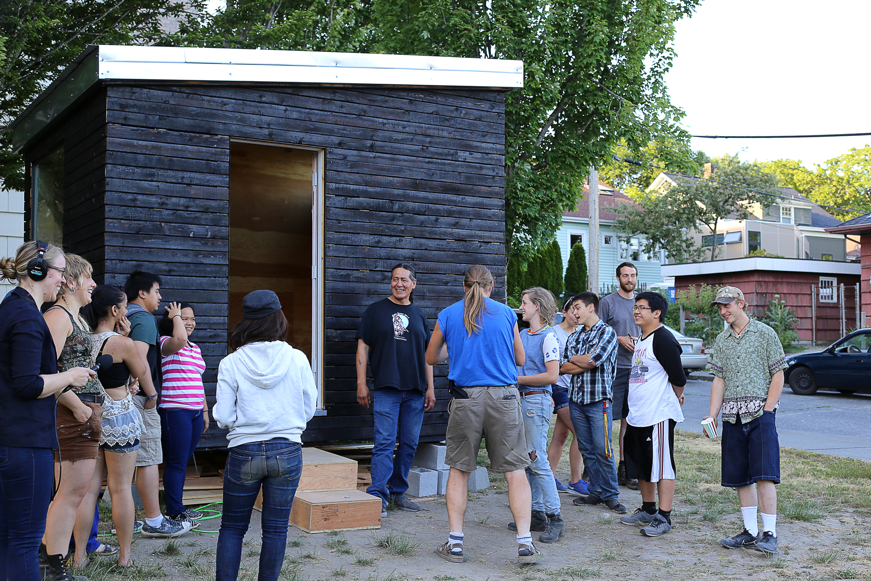 caption: The students of Sawhorse Revolution ceremonially hand over "The Nest" to Nickelsville resident John Hord (center).