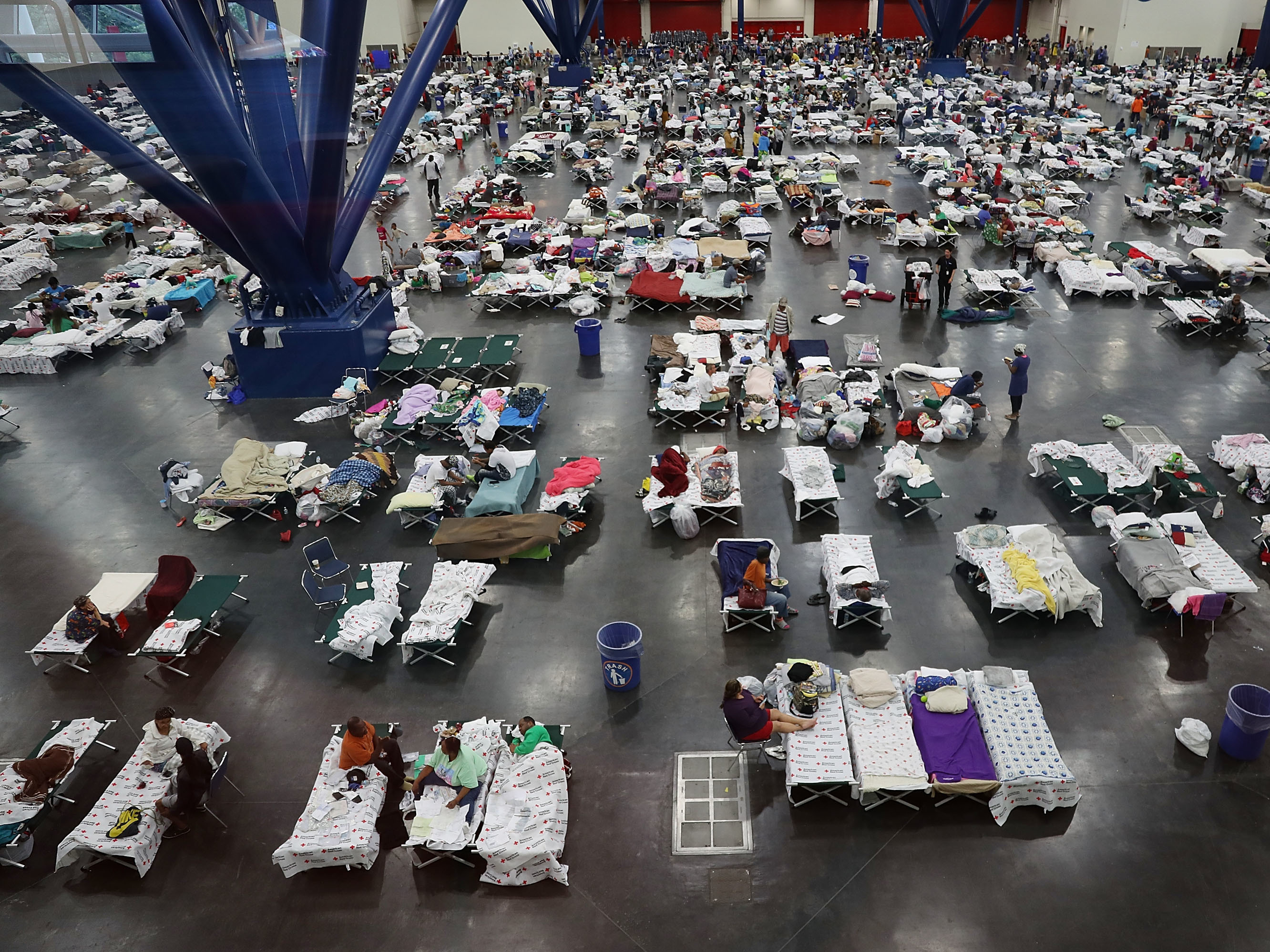 caption: In August 2017, the George R. Brown Convention Center in Houston was over capacity after floodwaters from Hurricane Harvey inundated the city. This hurricane season, congregate shelters — from school gyms to vast convention centers — risk becoming infection hot spots if evacuees pack into them as they have in the past.