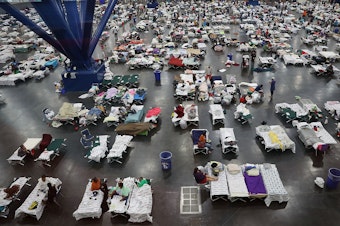 caption: In August 2017, the George R. Brown Convention Center in Houston was over capacity after floodwaters from Hurricane Harvey inundated the city. This hurricane season, congregate shelters — from school gyms to vast convention centers — risk becoming infection hot spots if evacuees pack into them as they have in the past.