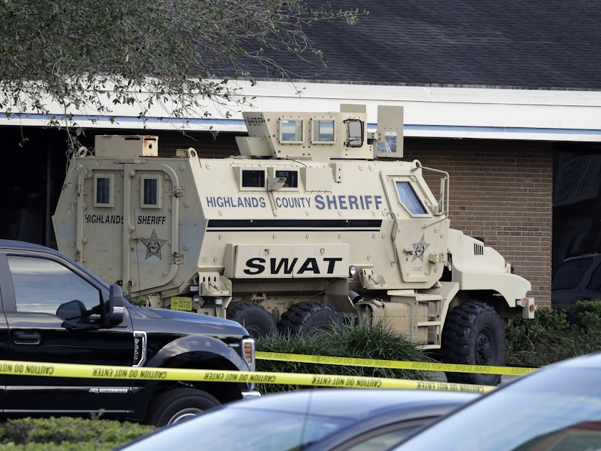 caption: A Highlands County Sheriff's SWAT vehicle is stationed in front of a SunTrust Bank branch, Wednesday in Sebring, Fla., where authorities say five people were killed in a shooting.