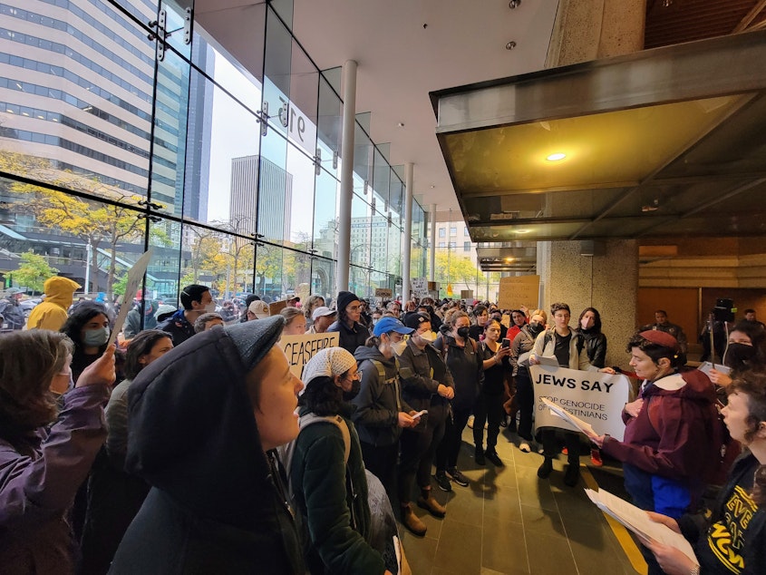 caption: Protestors packed into the lobby of the Henry M. Jackson Federal Building on Tuesday, October 17, 2023.