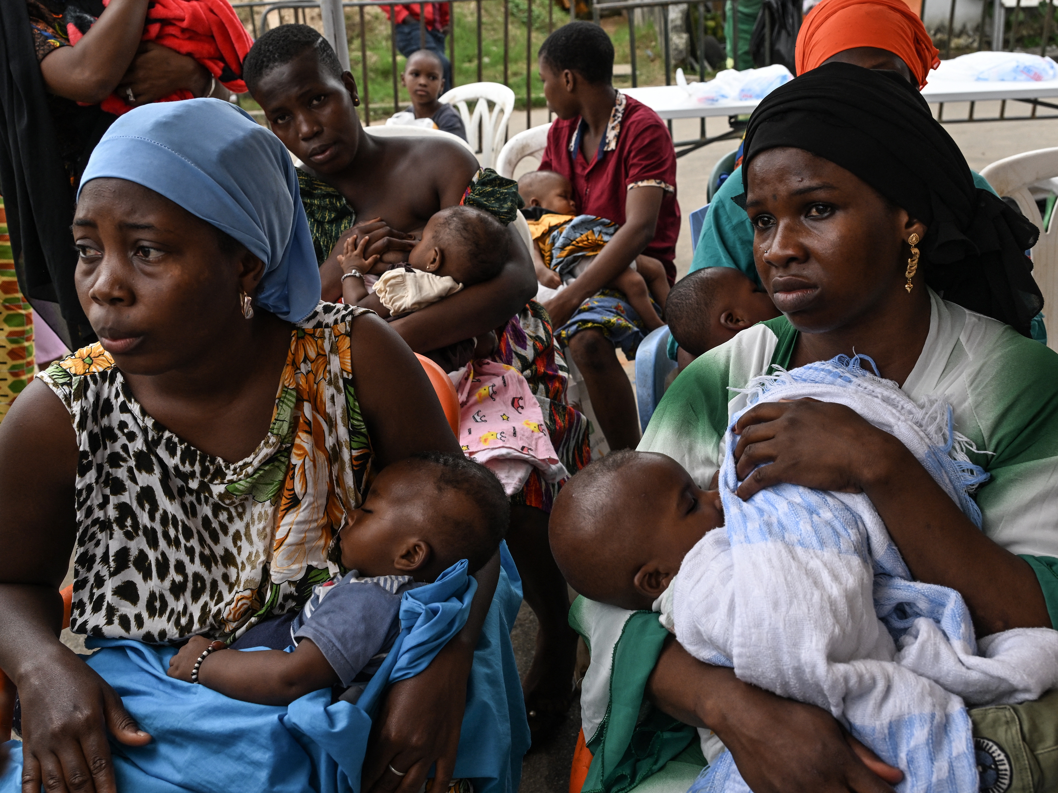 caption: Women breastfeed their babies while waiting to have them vaccinated against malaria in a district in Ivory Coast. Malaria is a major cause of death for children under 5.