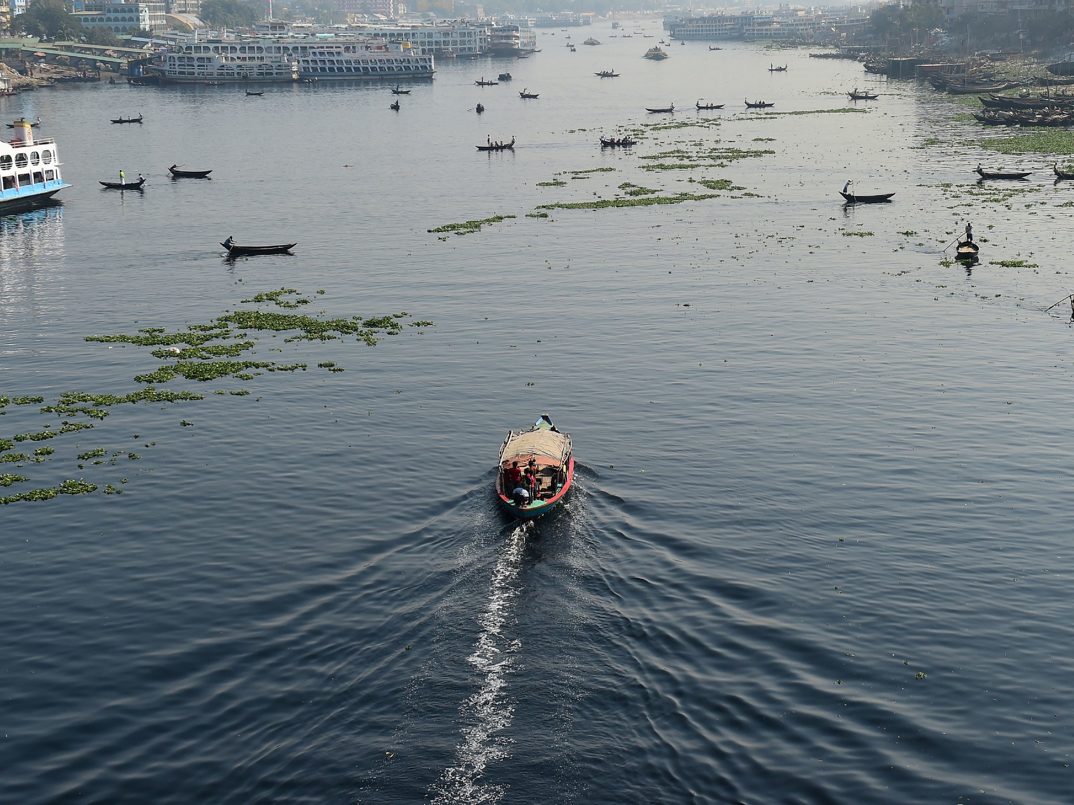 caption: Bangladeshi commuters use boats to cross the Buriganga River in the capital Dhaka in 2018. In July, Bangladesh's top court granted all the country's rivers the same legal rights as humans.