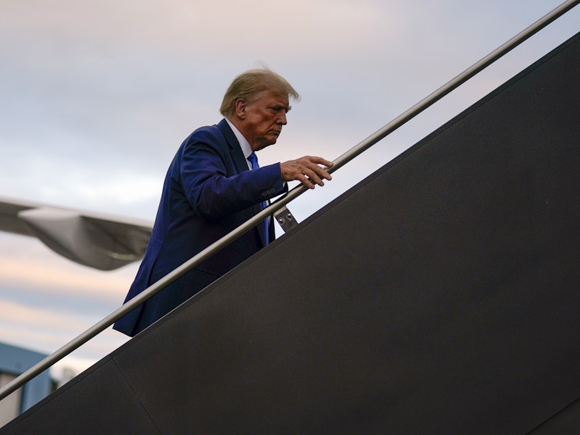 caption: Republican presidential candidate former President Donald Trump boards his plane at Manchester-Boston Regional Airport on Monday.