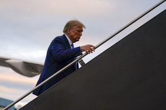 caption: Republican presidential candidate former President Donald Trump boards his plane at Manchester-Boston Regional Airport on Monday.