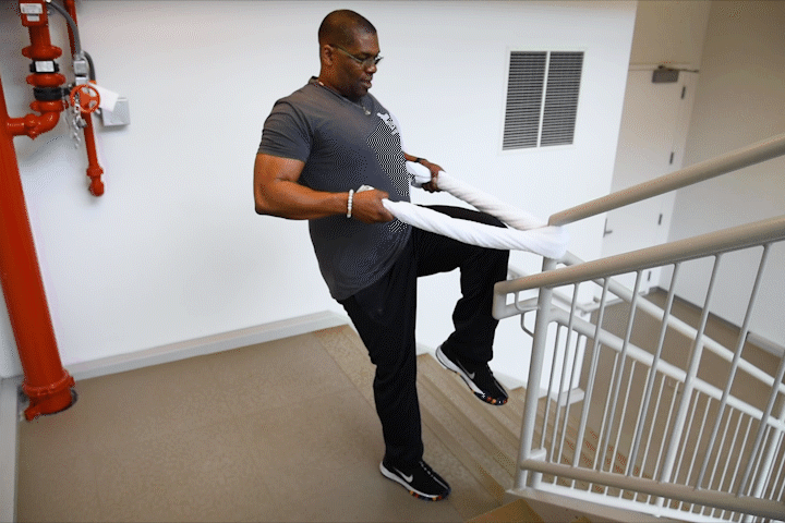 caption: For a bigger challenge, lift your leg off the ground, bending and extending it as you row.