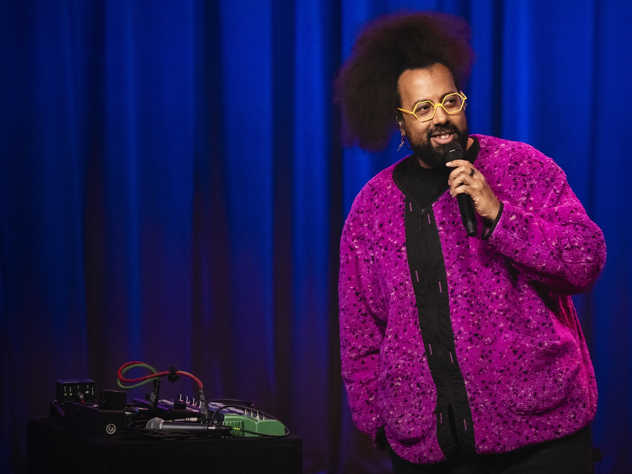 caption: Reggie Watts performs at TED2024