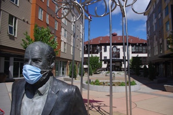 caption: The statue of Roberto Maestas, founder of El Centro de la Raza in Seattle, is adorned with a mask during the coronavirus pandemic. The plaza was redeveloped in 2016. 
