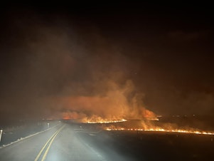caption: Fire crosses a road in the Smokehouse Creek fire in February in the Texas panhandle.