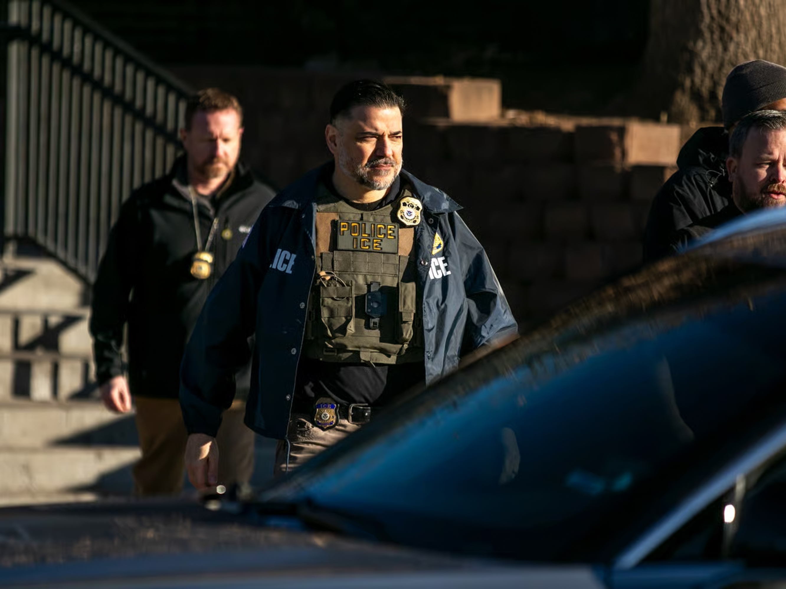 caption: Federal law enforcement agents outside a metro Denver apartment complex during an immigration raid Feb. 5, 2025