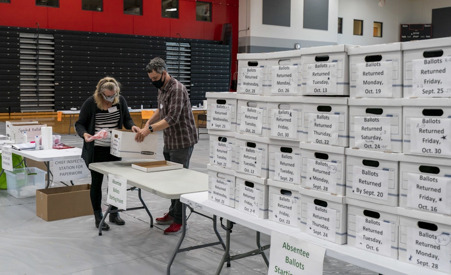 caption: Poll workers Angela and Zach Achten check-in a box of absentee ballots in the gym at Sun Prairie High School on November 3, 2020 in Sun Prairie, Wisconsin. (Andy Manis/Getty Images)