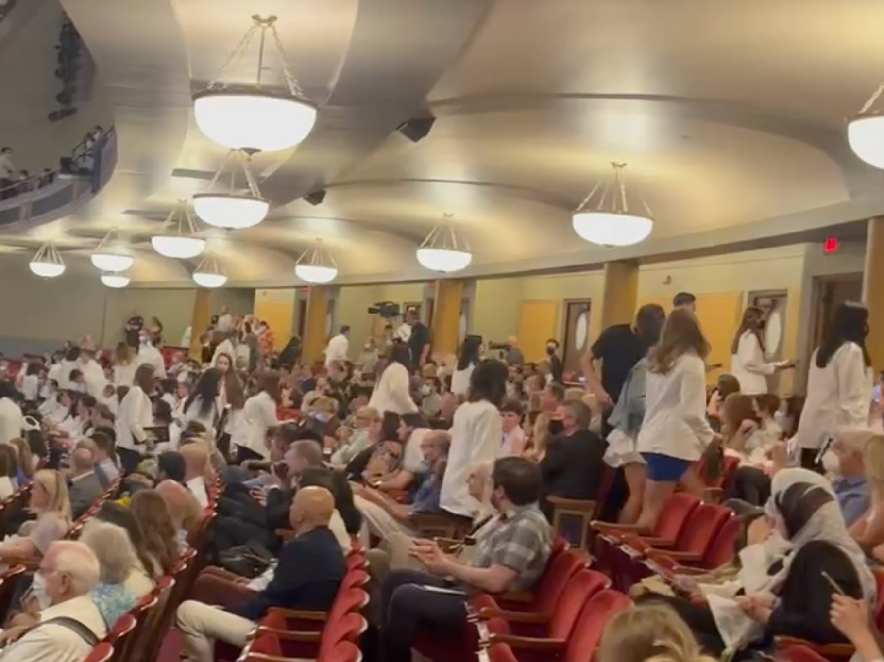 caption: After receiving their white doctor's coats, dozens of incoming medical students at the University of Michigan walked out in protest of a keynote speaker with anti-abortion beliefs.
