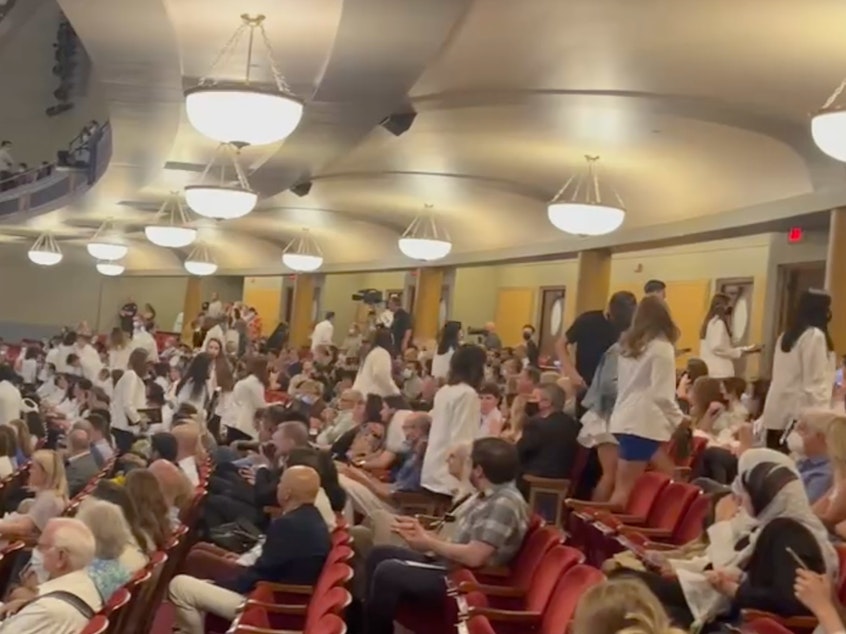 caption: After receiving their white doctor's coats, dozens of incoming medical students at the University of Michigan walked out in protest of a keynote speaker with anti-abortion beliefs.