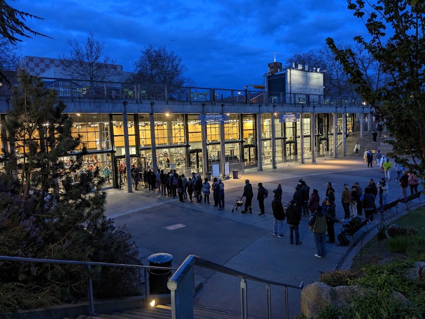 caption: People line up before dawn on Thursday, April 27, 2023, at Seattle Center's Fisher Pavilion for the Seattle/King free health clinic