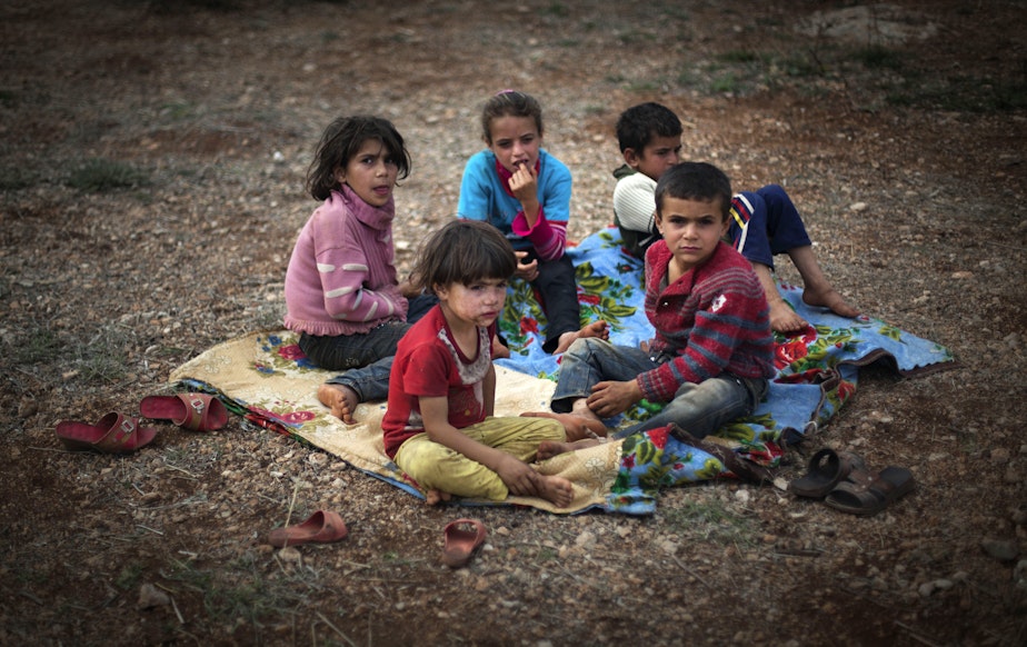 caption: Syrian children who fled with their families from the violence in their village, sit on the ground at a displaced camp in the Syrian village of Atmeh, near the Turkish border with Syria, Thursday, Nov. 8, 2012.