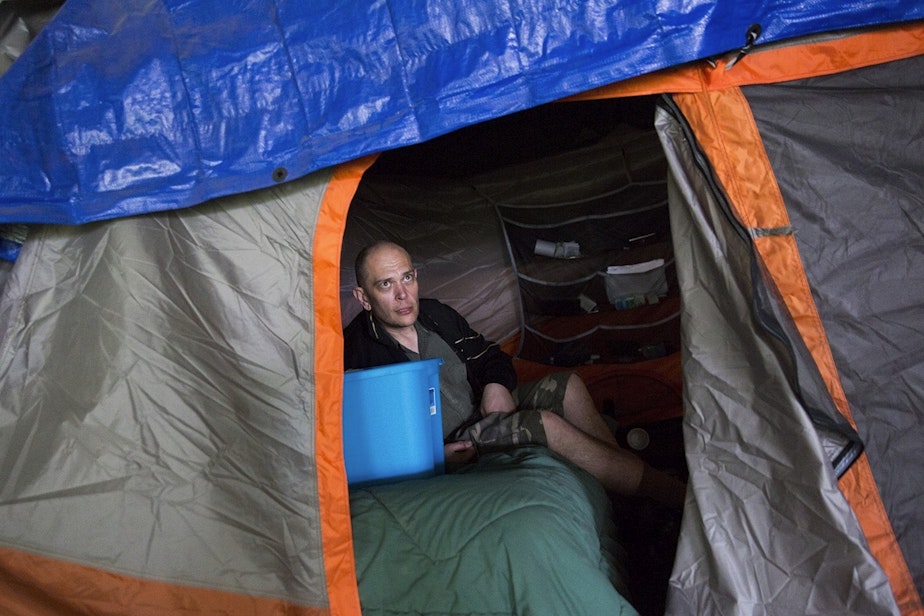 caption: Kevin Boggs in his tent in the Jungle, before the tent encampment was torn down in 2016. Boggs was signed up at methadone clinics because of an addiction.