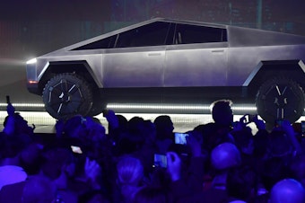 caption: Tesla's Cybertruck, pictured here during its design reveal in Hawthorne, Calif., in 2019, is finally rolling out of factories a full two years after the initial delivery target.
