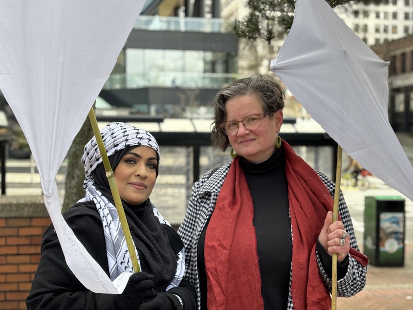 caption: Naazneen Ali and Alouise Urness hold white kites symbolizing their support for the people in Gaza on March 4, 2024. Ali and Urness said they would vote "uncommitted" in Washington's Democratic presidential primary to urge President Joe Biden to call for a ceasefire in Gaza.