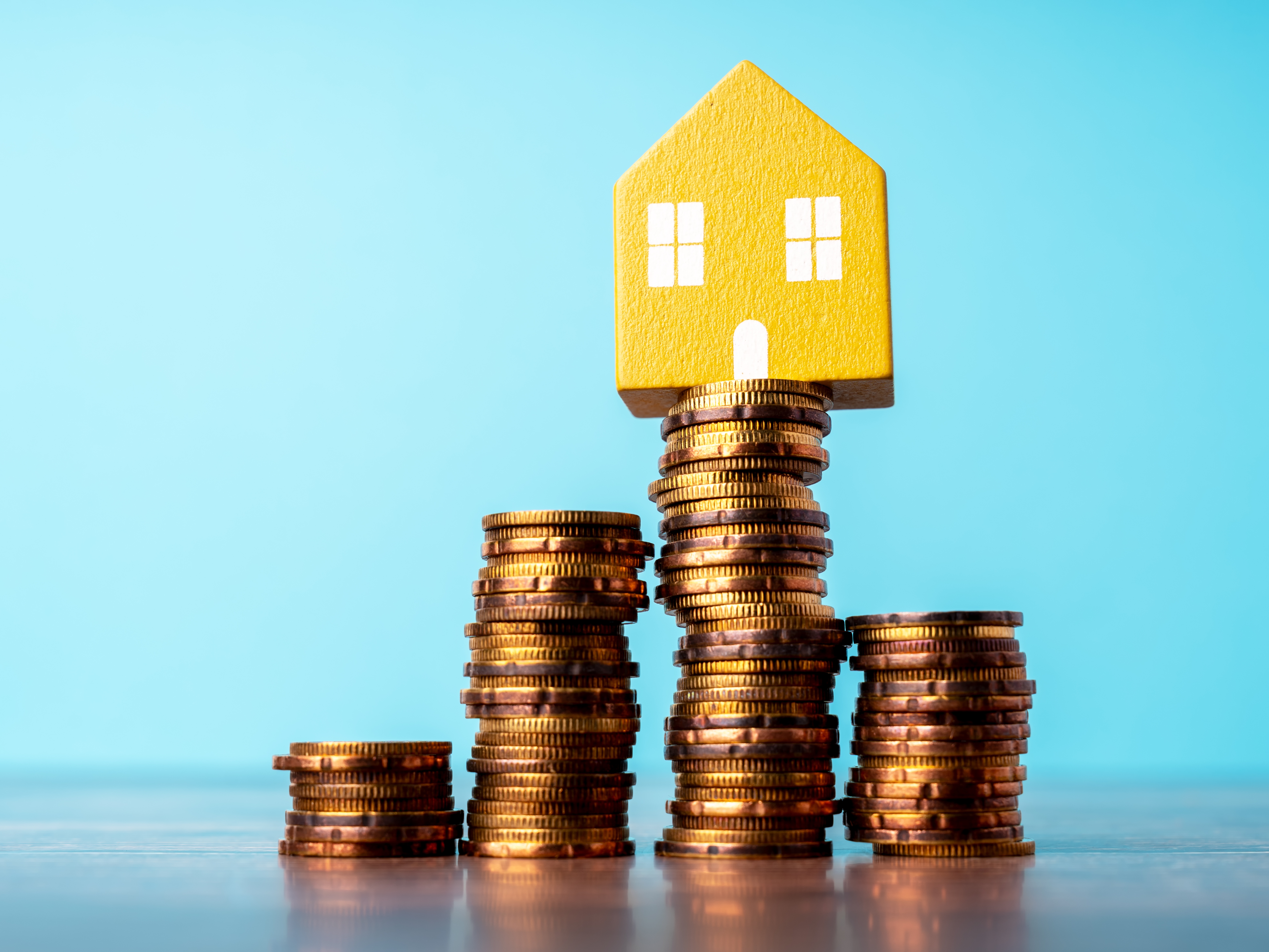 House Model on Top of Stack of Coins