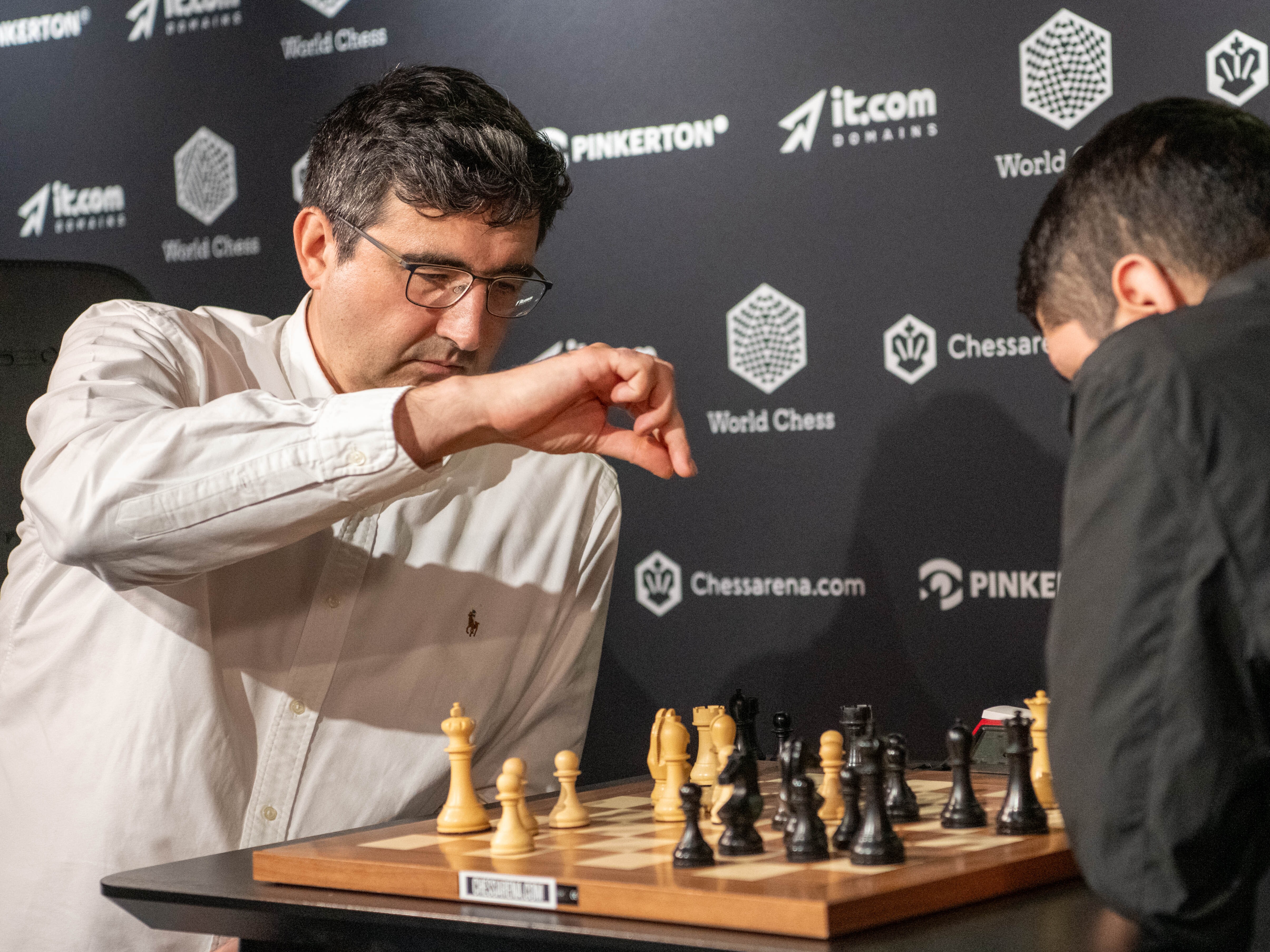 caption: Chess Grandmasters Vladimir Kramnik (left) and José Martínez Alcántara face off at the World Chess Clash of Blames tournament on Aug. 19, 2024, in London. The International Chess Federation said Wednesday it is investigating Kramnik for allegations of cheating he levied at Daniel Naroditsky and other elite players.