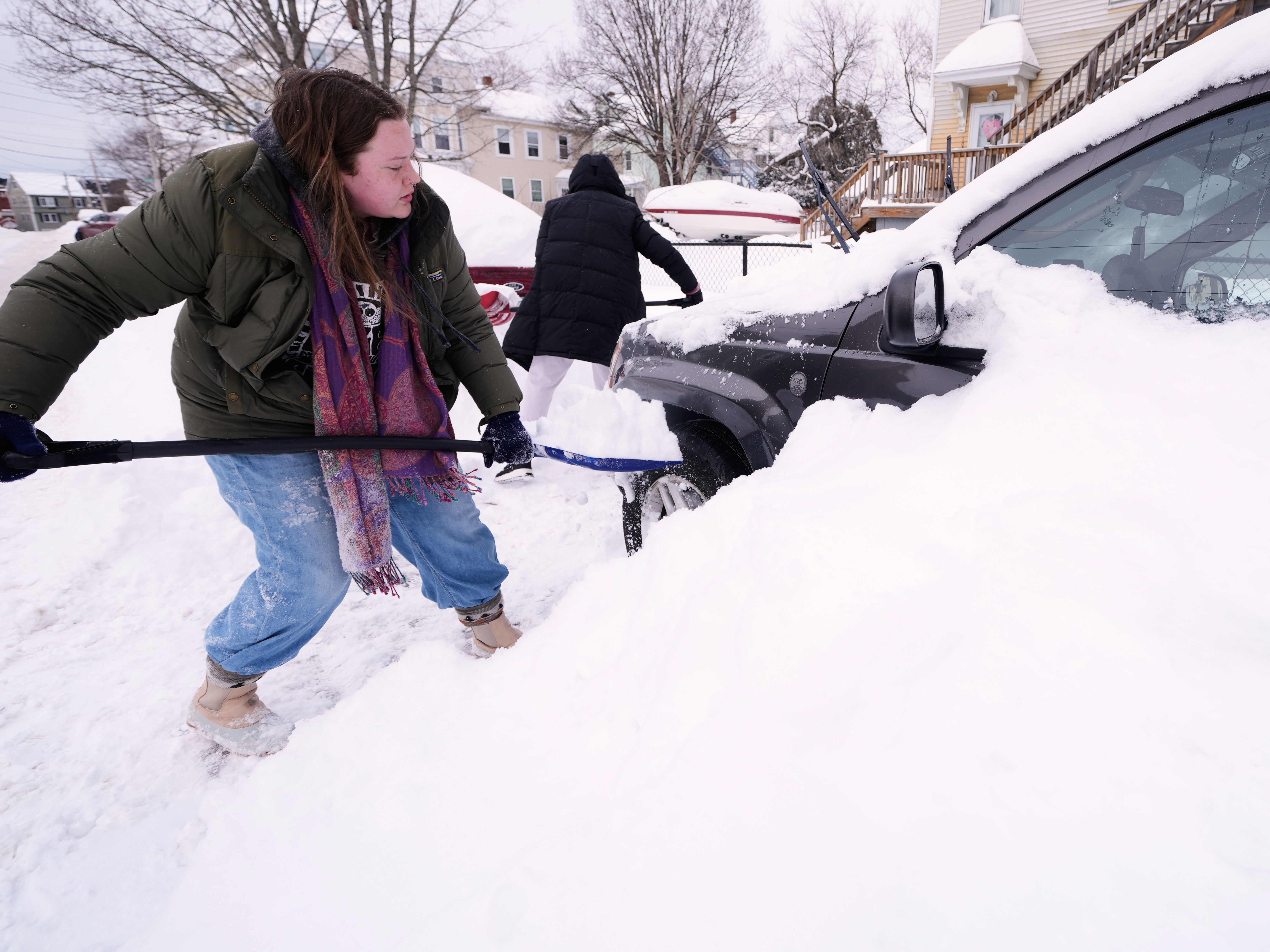 caption: Emma Teske shovels out her car following a winter storm that dumped more than a foot and a half of snow across the region on Tuesday in Haverhill, Mass.