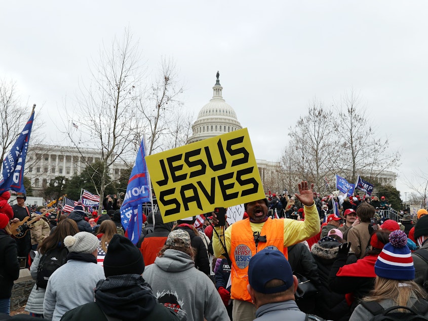 caption: A yellow banner that reads JESUS SAVES stands out in the pro-Trump mob outside the U.S. Capitol Building on Wednesday.