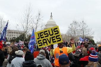 caption: A yellow banner that reads JESUS SAVES stands out in the pro-Trump mob outside the U.S. Capitol Building on Wednesday.