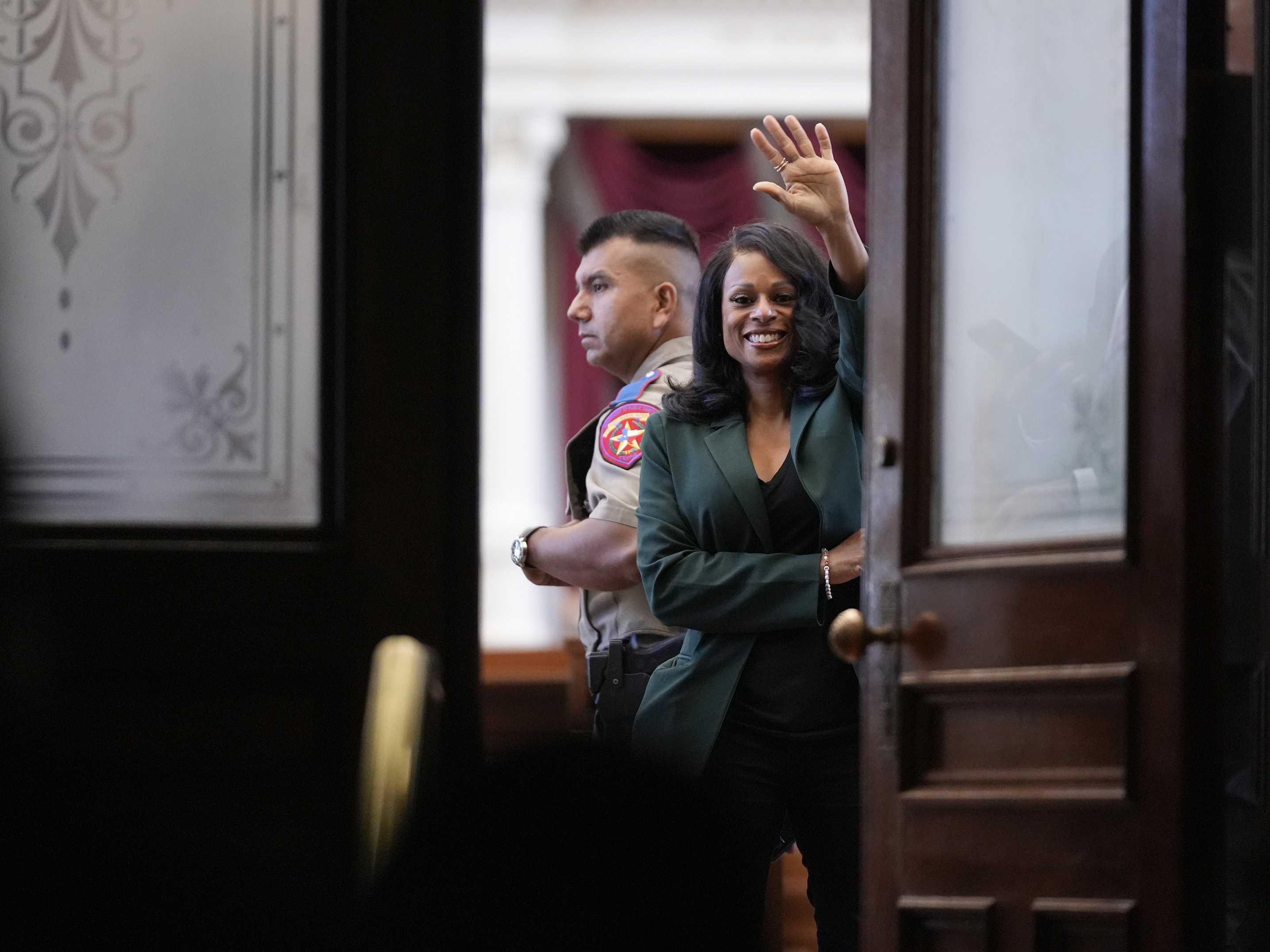 caption: Rep. Nicole Collier, D-Fort Worth, waves to supporters from the House Chamber at the Capitol in Austin, Wednesday morning, Aug. 20, 2025, after spending two nights in the chamber for refusing to sign a permission slip to leave.